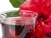 Fotografía de un vaso con una té o infusión de flor de jamaica.