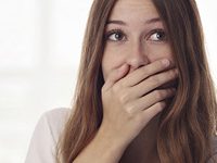 Fotografía de una mujer tapándose la boca porque tiene hipo